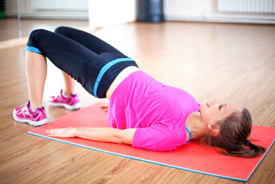Picture of a female performing a floor exercise in a gym with a mat.