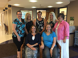 Photo of the seven female employees of the business office dressed in business attire