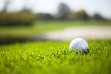 A golf ball sitting in a bed of green grass