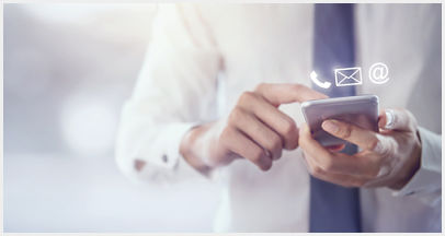 A man holding a cell phone with icons for a phone, envelope, and @