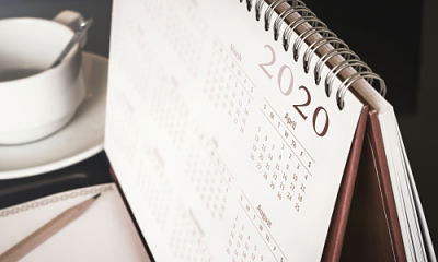This is a picture of a calendar with all the months of 2020 with a coffee cup in the background.