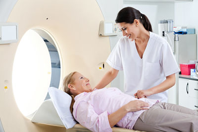 Picture of a female radiology tech performing a MRI scan for a female patient.