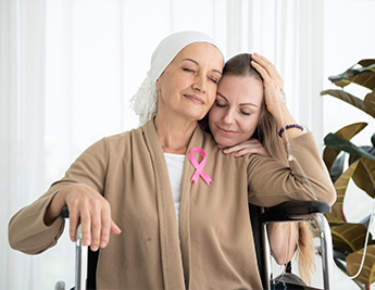 Daughter holding and hugging mother that has cancer.