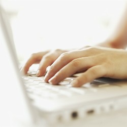Picture of a person typing on an opened laptop